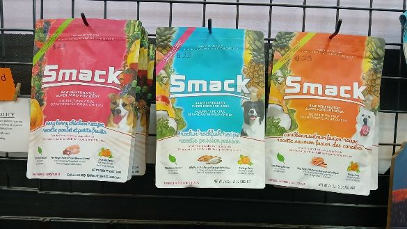 Smack dog treats in a variety of flavors hanging on a rack